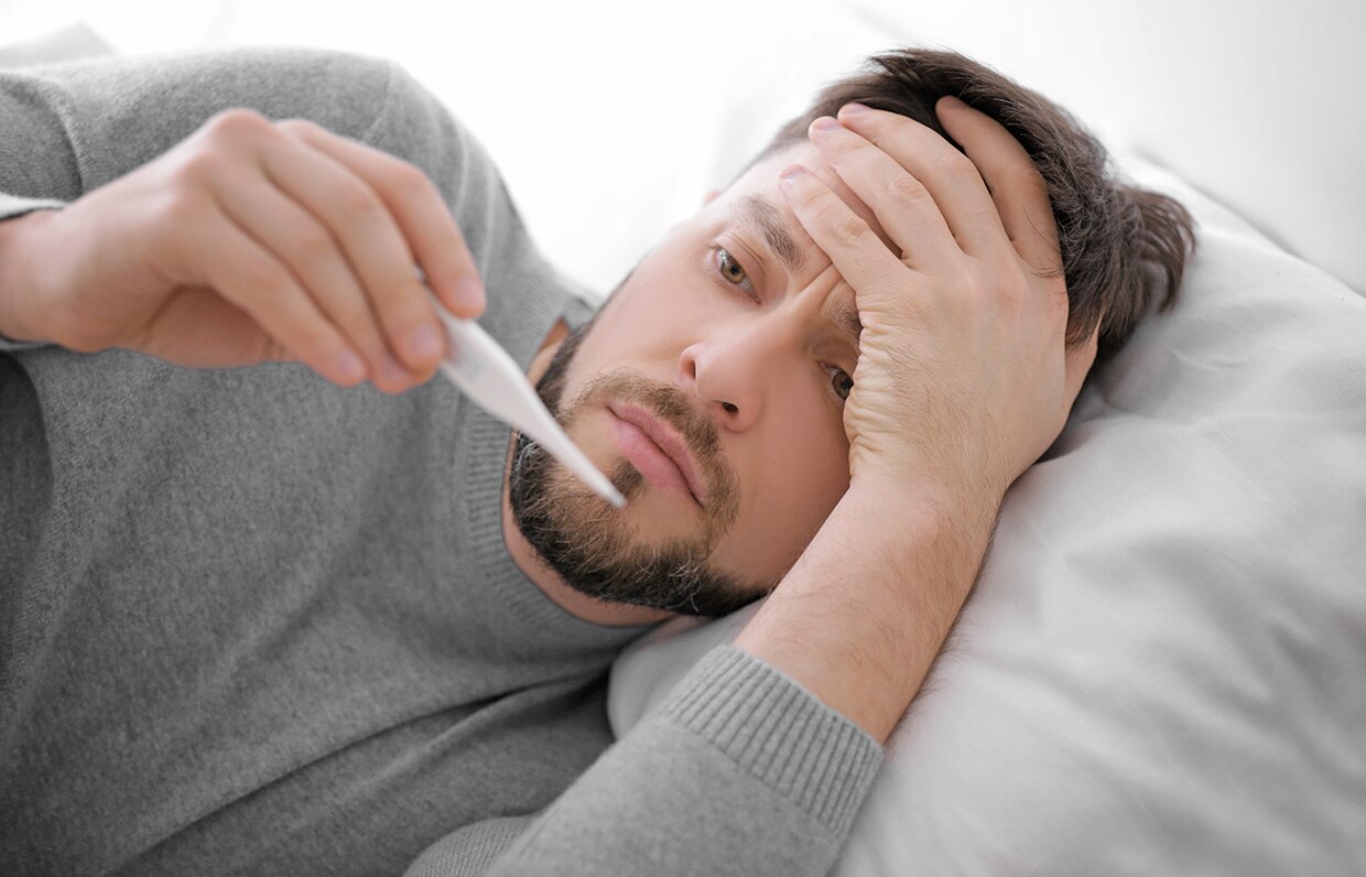 muž v posteli s teplomerom