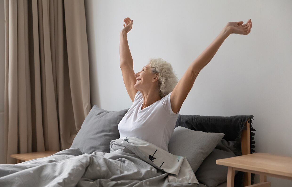 žena v posteli, ktorá sa naťahuje a zotavuje