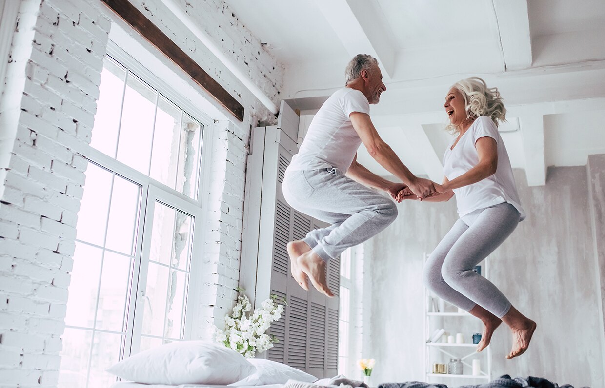 starší pár skákajúci na posteli