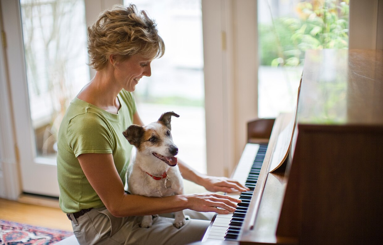 žena so psom hrajúca na klavíri